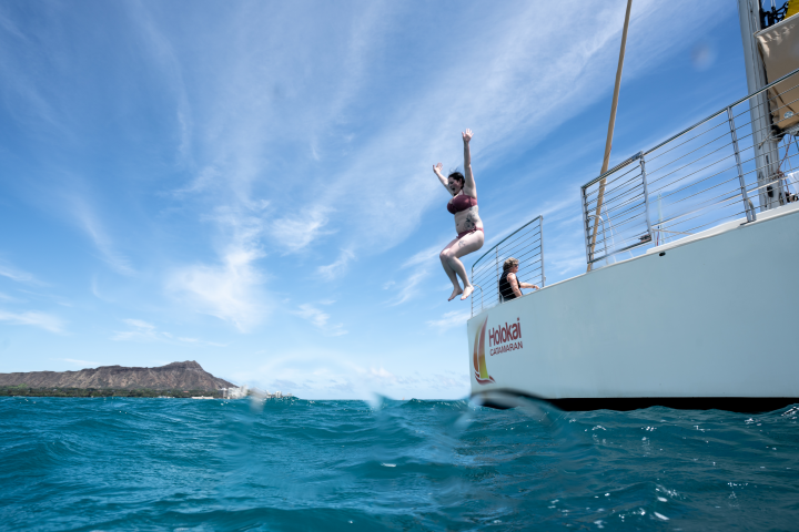 Woman jumping in to water from boat